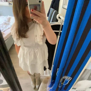 volangklänning  - En vit volangklänning med volang både på över och underdel. Volangerna har brodyr på sig. Klänningen är från hm och har pristlappen kvar💕