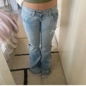 SNYGGASTE JEANSEN💕 - såå snygga bootcut lågmidjade jeans med hål!! kolla sista bilderna för att se midjemått, innerbenslängden är 71cm.  (Dem är avklippta som ni ser på sista bilden)💕💕