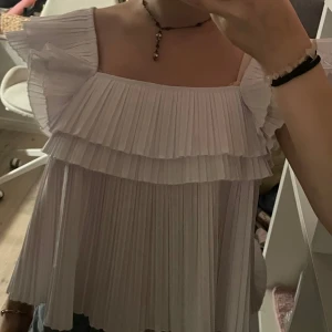 Vit blus med volanger 💕 - Säljer en superfin ny skick blus med volanger. Perfekt för sommardagar eller festliga tillfällen. Toppen har en luftig passform och är gjord i ett lätt material som känns skönt mot huden. Säljer då den tyvärr inte kommer till användning 💕💕 LÄGG GÄRNA PRISFÖRSLAG!💕
