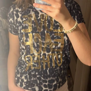 Leopardmönstrad t-shirt - Säljer en cool leopardmönstrad t-shirt från Minymo med texten 'LOVE EACH OTHER' i guld💛storleken är 146cm men jag skulle säga XS (jag är 173cm)