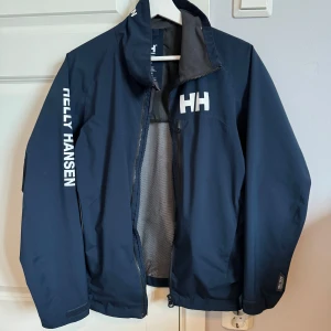 Helly Hansen - Helly Hansen jacka i fint sick. Använd som en regn jacka i somras. Det finns inga skador eller liknande på jackan. Tveka inte på att höra av dig vid frågor eller funderingar.