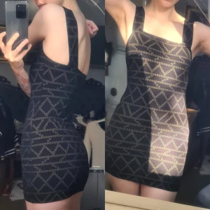 Mönstrad mini dress bodycon svart/guld XS - Bra skick, men missfärgad på mönstret fram. 88% viskos, 10% polyester, 2% elastan. Bystvidd: 33, midjevidd: 29, stussvidd: 37, längd fram: 61, längd bak: 51, strap bredd 4,5, strap längd: 37.