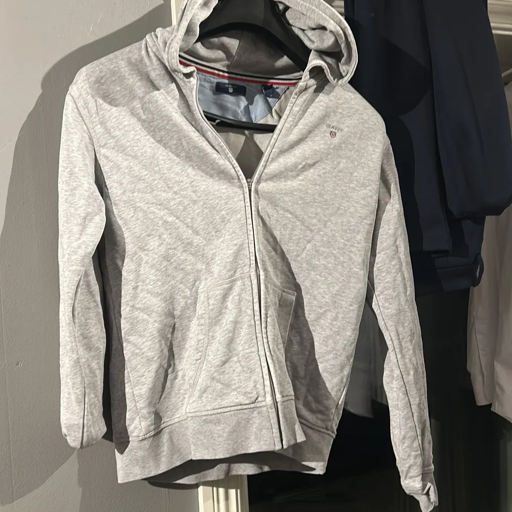 Säljer en stilren grå hoodie med dragkedja. Perfekt för både vardag och träning.  Den har en defekt vid dragkedjan (bild) men inget som stör. . Tröjor & Koftor.