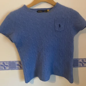 Stickad T-shirt från Ralph Lauren! - Blå stickad T-shirt från polo Ralph Lauren, passar som storlek xs/xxs dam då den krympt i tvätten. Perfekt skick och fin kvalitet med ull och Kashmir. Dyr i inköp!