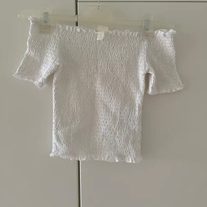 Vit topp från H&M - Vit topp från H&M i storlek XS. Sitter väldigt fint på! Använd 1 gång. 