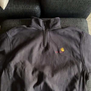 Carrhart half zip strl M - Säljer en svart tröja från Carhartt i storlek M. Den har en halv dragkedja och det klassiska Carhartt-logotypen broderad på bröstet. Perfekt för en avslappnad stil och passar bra till både vardag och fritid. Nypris 1300
