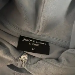 Säljer ett supermysigt blått velourset från Juicy Couture i storlek M. Setet består av en hoodie med dragkedja och byxor med fickor. Perfekt för en chill dag hemma eller en avslappnad utflykt. Setet är i mycket bra skick, använd 2 gånger ca, som ny. Säljer ej separat