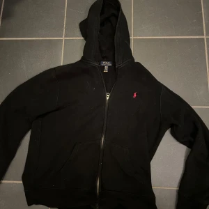 Svart zip hoodie från Ralph Lauren - Säljer en as skön svart hoodie från Ralph Lauren, perfekt nu för kallare tider. Storlek XL i ungdom men passar vanlig M. Självklart äkta. Säljer för att den inte kommer till använong något mer