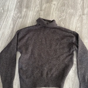 Mörkbrun polotröja - Säljer en stilren mörkbrun polotröja i mjukt material. Perfekt för kyliga dagar med sin höga krage och långa ärmar. Tröjan har en klassisk design som passar både till vardags och lite finare tillfällen. Ett måste i garderoben för höst och vinter!