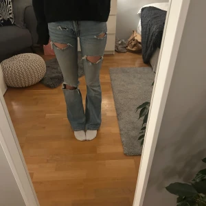 Blå jeans med slitningar - Säljer ett par snygga blå jeans med hål. Har sytt om de mer lågmidjad.