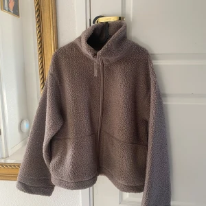 Ny brun pilejacka teddyjacka från HM - Ny med tags. Färg: brun / mörkbeige. Storlek: M Passformen är i en normal avslappnad form. Ta en storlek större än din vanliga storlek om du vill ha plats för en tjocktröja under annars kan det blir lite tajt. 