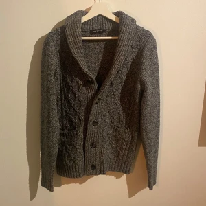 Stickad cardigan - Säljer en grå stickad cardigan i ull. Nyskick. Passar perfekt nu till vintern. Hör gärna av er vid fler frågor eller bilder!
