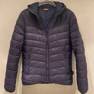 Napapijri Jacka - Säljer en snygg mörkblå pufferjacka från Napapijri. Jackan har en quiltad design med dragkedja och en praktisk huva, den är i storlek S. Perfekt för kyliga dagar, jackan är i mycket bra skick.🙌❄️(Nypris: 1749kr) Hör av er om ni har någon fråga!😁💯