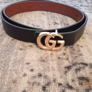 Säljer ett stilrent svart skärp från Gucci i skinn med den ikoniska GG-loggan i guld. Perfekt för att ge din outfit en lyxig touch. Skärpet är i nytt skick och passar både till vardag och fest. Ett måste för modeälskare! 🖤✨