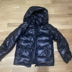 Monclear  - MONCLEAR LIKNANDE jacka, jackan har inget märke då jag fått den som gåva , en svart pufferjacka i mycket bra skick. Aldrig använde Den är perfekt för kalla vinterdagar, jackan kom ej med prislapp pris kan diskuteras 