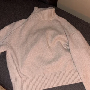 Beige stickad polotröja - Mysig beige stickad polotröja i storlek xs från H&M. Perfekt för kyliga dagar med sin höga krage och långa ärmar. Tröjan har en ribbad kant vid ärmslut och nederkant, säljer pga av att jag inte tycker om den höga kragen så mycket och därför kommer den inte till användning🩵