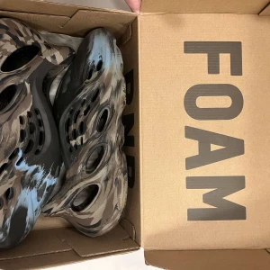 Camouflage mönstrade Foam Runners - Säljer ett par Adidas Foam Runners i ett coolt camouflage mönster. De är i syntetmaterial och har en unik design med hål för ventilation. Perfekta för sommarens alla äventyr! 🏖️ ( kan gå ner i pris vid snabb affär!!