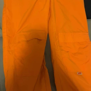 Orange cargobyxor - Säljer ett par coola orange cargobyxor. Perfekta för en avslappnad och trendig look. Byxorna har flera fickor och är i ett slitstarkt material. Passar perfekt för höst och vår.