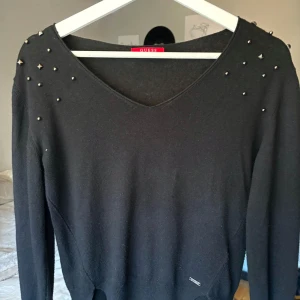 Guess tröja med nitar - Säljer en snygg svart tröja från Guess nitar/pärlor på axlarna. 
