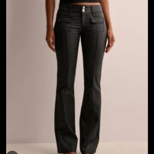 Svarta bootcut jeans  - Snygga svarta bootcut byxor i skinnliknande material, lågmidjade med vacker passform. Passar perfekt till fest men även till vardags med en stickad tröja, kan stylas på många olika sätt. Byxorna/jeansen är ifrån Nelly men är slutsålda och borttagna från hemsidan. Dessa är endast använda max 1 gång och har därmed inga defekter och är i nyskick. Jag är 169 cm och både med och utan klackar så sitter de perfekt. ☺️💗