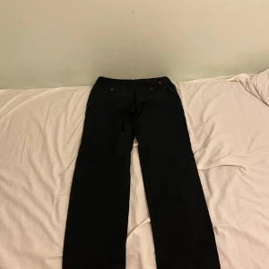 Svarta byxor från Polo Ralph Lauren chinos - Säljer ett par stilrena svarta byxor från Polo Ralph Lauren. De har en klassisk design med rak passform och är perfekta för både vardag och fest. Byxorna är i mycket bra skick och har en elegant look som passar till alla tillfällen.