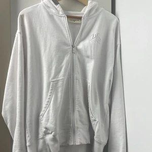 Vit kofta från YoungLA - Jätte snygg och skönt YLA kofta hela vägen från USA så leveransen och tullen var dyr. 9/10 skick då jag inte använt den mycket alls. Perfekt till gym och vinter tid. Pris diskuteras! NyPris 700kr 