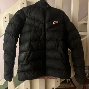 Svart vinterjacka från Nike - Säljer en svart vinterjacka från Nike i hyfsat bra skick. Den har ett litet hål på framsidan som syns på sista bilden. Skulle säga att storleken är xs