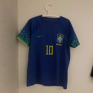 Blå Brasilien fotbollströja Neymar Jr - Säljer en blå Brasilien fotbollströja med Neymar Jr på ryggen. Har använt den några gånger men den är i bra skick. Storlek M
