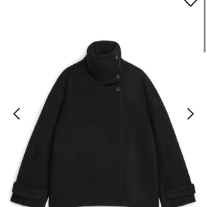 Arket kappa - Svart jacka i luddig ullblandning - Säljer en stilren svart jacka i luddig ullblandning. Den har en hög krage med knappar och långa ärmar med uppvikta muddar. Perfekt nu till höst/vinter samt våren som kommer. Använd en vinter.