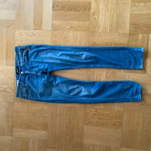 Blå jeans från Replay - Säljer ett par snygga blå jeans från Replay, modell Grover. De har en klassisk femficksdesign och en bekväm passform. Färgen påminner väldigt mycket om dundup jeans och sitter ungefär som dundup. Säljer pga att jag har växt ur dem. Inga defekter, fläckar eller annat anmärkningsvärt. Va inte rädd att ställa frågor, kan sänka pris vid snabb affär(1-3 dagar)