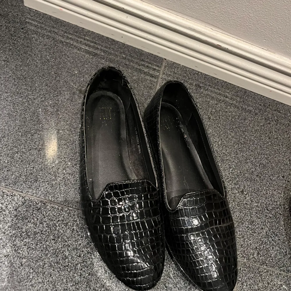 Snygga svarta loafers i skinn med ett coolt krokodilmönster. Perfekta för både vardag och fest! De har en klassisk design med en bekväm passform. Ett måste för garderoben om du vill ha något stilrent och tidlöst.. Skor.