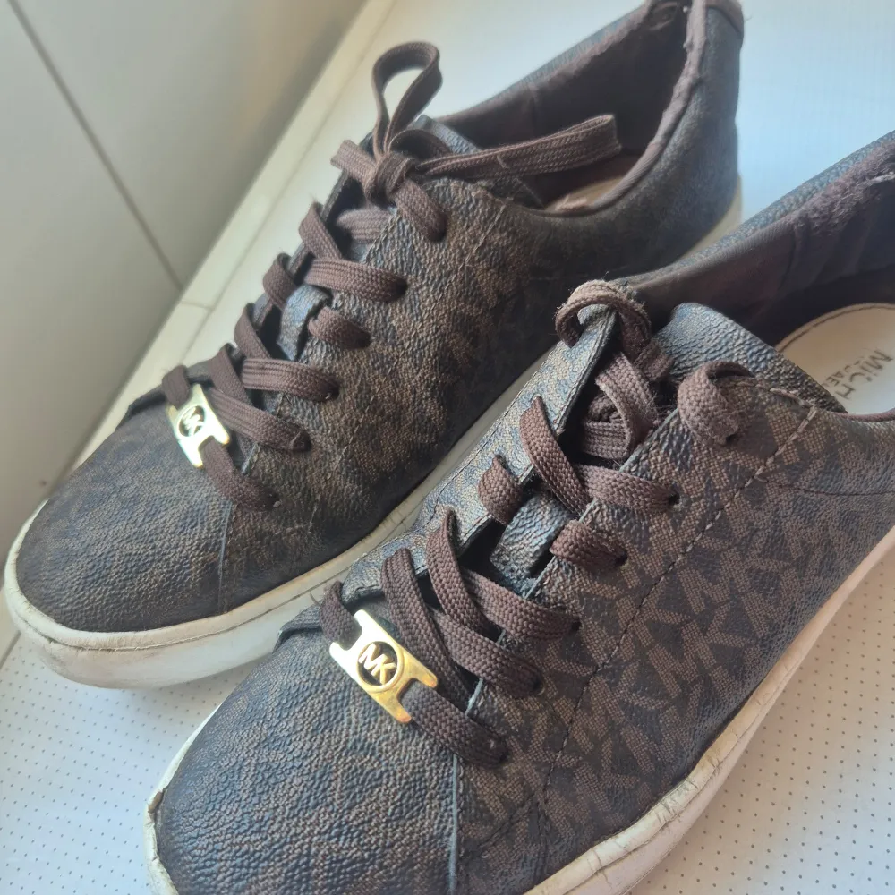 Säljer ett par bruna sneakers från Michael Kors i begagnat skick , dock så har ena märket lossnat på baksidan man kan säkert sy ihop från skräddare. Nypris 1600 säljer dom för 300. Skor.