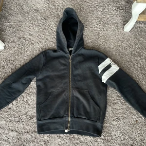 Svart hoodie från Moncler (byten kan vara intressant) - Säljer en snygg svart moncler hoodie som är köpt från vongrevencloset i mycket bra skick. Den har en dragkedja framtill och en fet vit rand med Moncler-logga på ärmen. Perfekt för höst och vinter då den är väldigt varm. Hör av vid fler frågor! Byten funkar