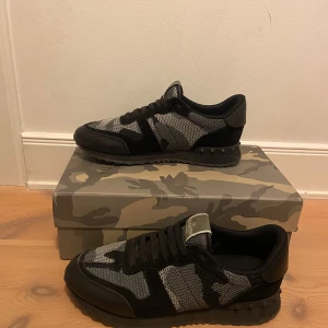 Valentino Rockrunner i camouflage - Säljer ett par snygga Valentino Rockrunner sneakers i svart och grått camouflage. Skorna är i mycket bra skick och kommer med originalförpackning och tillbehör. Pris kan diskuteras.