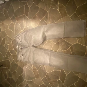 Grå jeansbyxor - Säljer ett par grå jeansbyxor i bra skick. De har en klassisk straight passform och är perfekta för både vardag och fest. Byxorna har en dragkedja och knappar framtill. Perfekta för höst och vår!