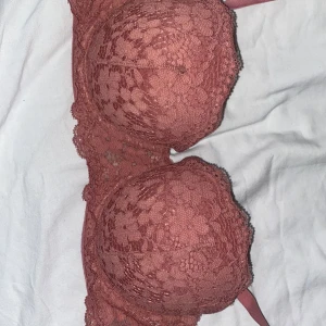 Rostrosa spets-BH från H&M - Säljer en superfin rostrosa BH från H&M i storlek 75B. Den är täckt med vacker spets och har en bekväm passform. Perfekt för både vardag och speciella tillfällen. Använd fåtal gånger, så den är i mycket bra skick! 💖