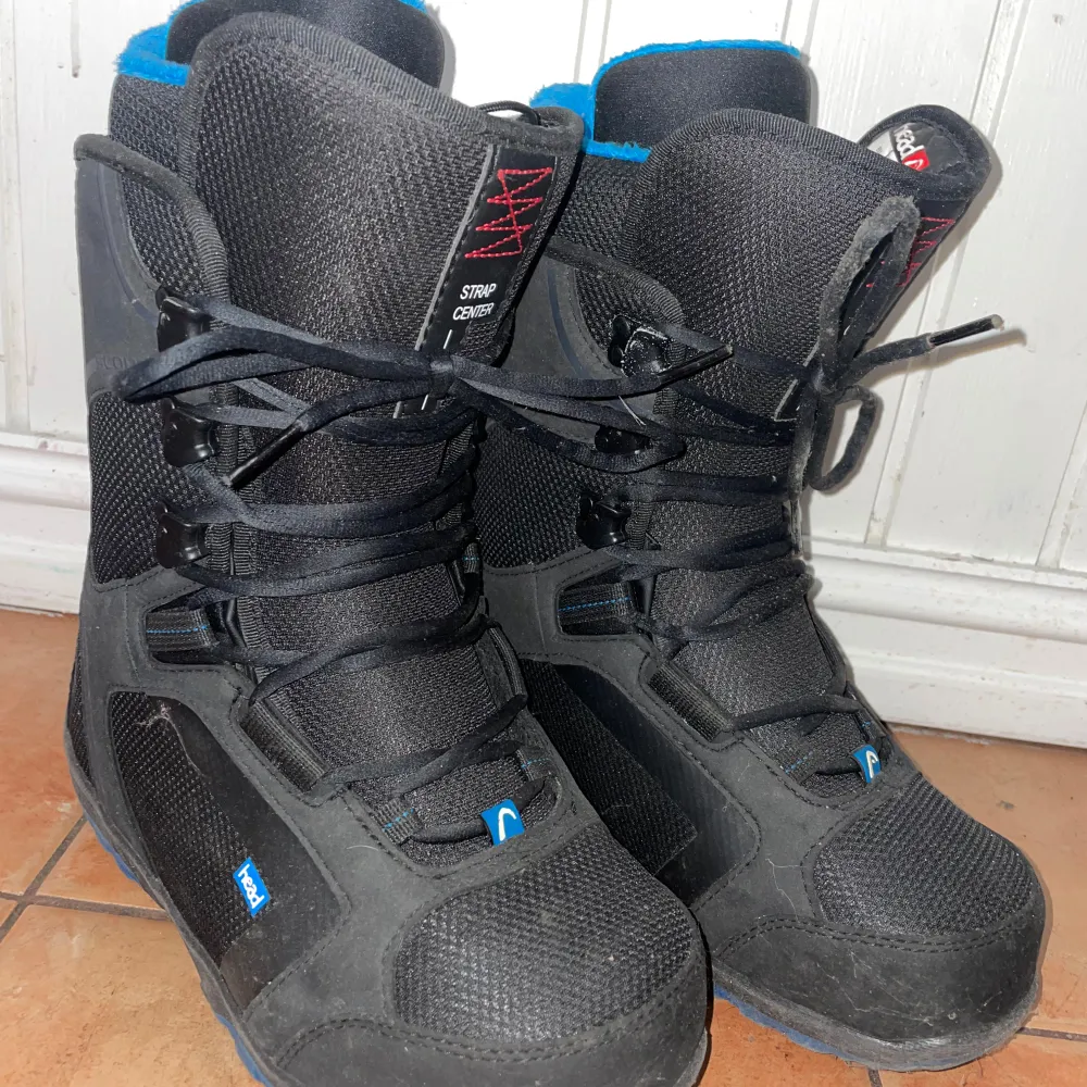 Säljer ett par svarta snowboardboots från Head i storlek 39.5. De har en cool blå insida och snörning framtill för bra passform. Perfekta för vinterns äventyr i backen! Endast använda ca 6/7 åkdagar 🏂. Skor.