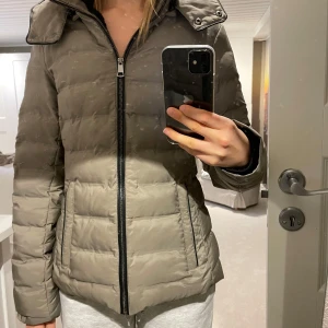 Beige dunjacka från Zara - Säljer en snygg beige dunjacka från Zara i storlek S. Jackan har en dragkedja framtill en luva.  Perfekt för kyliga höst- och vinterdagar. Den är i mycket bra skick och supermysig att ha på sig. Passar både till vardags och lite finare tillfällen. Skriv för mer detaljerade bilder!!! 