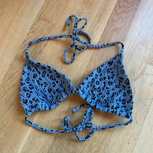 Blå och svart bikiniöverdel - Säljer en snygg blå och svart bikiniöverdel med leopard mönster. Den har knytband i nacken och ryggen för justerbar passform. Endast använd 2 gånger & sen tvättad! 🩵 från nakd