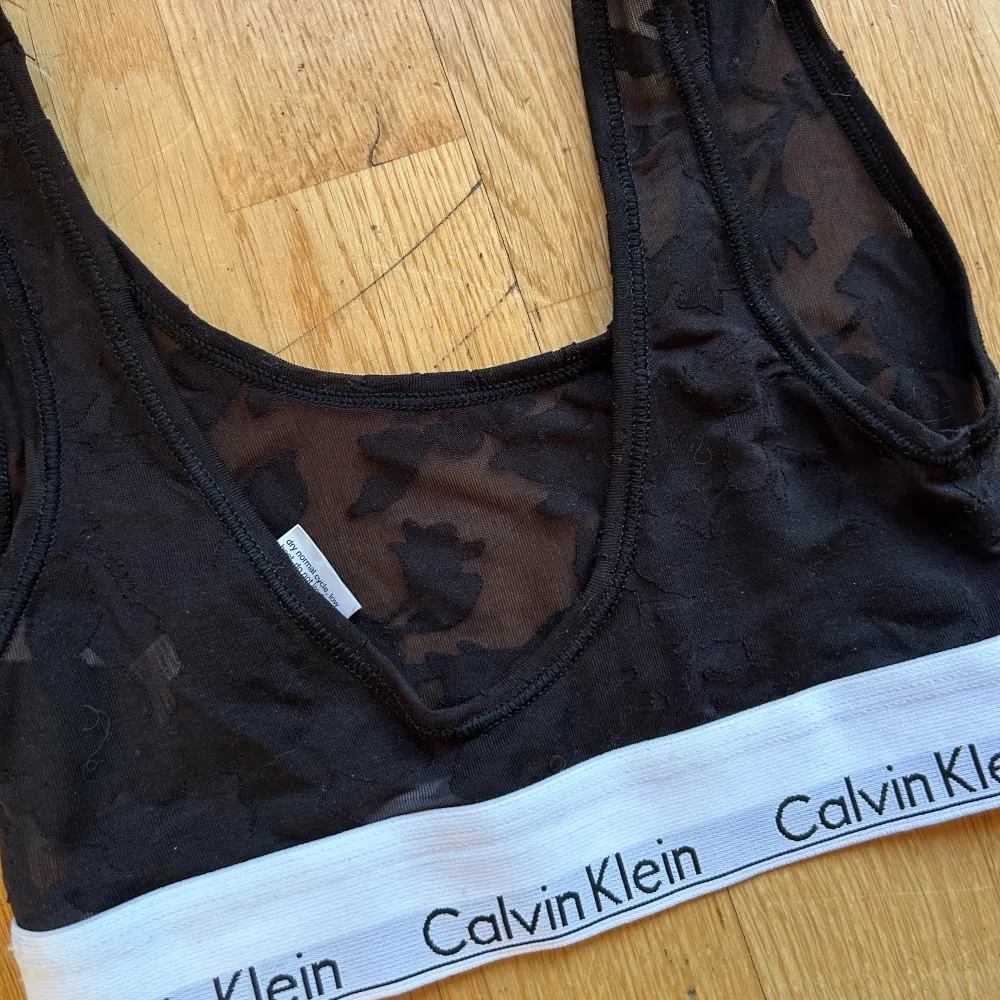 Säljer en snygg svart bralette från Calvin Klein i storlek XS. Den har en elastisk vit kant med Calvin Klein-loggan och är tillverkad i ett mjukt och bekvämt material. Perfekt för vardagsbruk eller under en lös topp. 🖤 aldrig använd . Toppar.