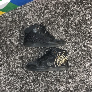 Nike sb dunk Faust  - Säljer ett par Nike Sb dunk Faust med unik graffiti-design i guld och svart. Skorna är i 7/10 skick om du har några frågor så är de bara att skriva.
