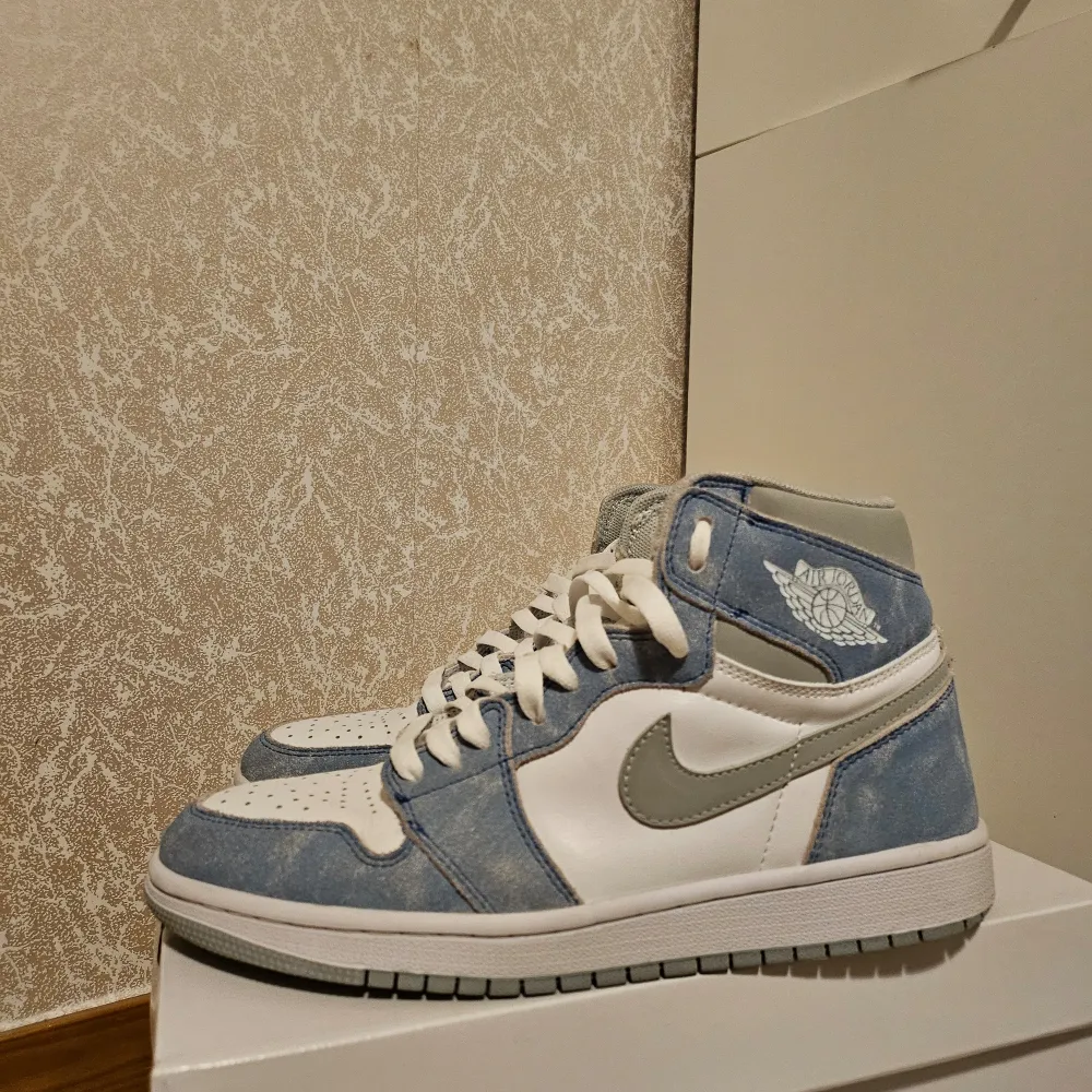 Säljer ett par Nike Air Jordans i snygg blå och vit färgkombination. Skorna har en klassisk design med snörning och en stilren grå swoosh. Perfekta för både vardag och fest! De är i nytt skick.. Skor.