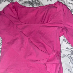 Rosa långärmad topp - Säljer en superfin rosa långärmad topp i mjukt material. Perfekt för både vardag och fest! Den har en enkel design med rund halsringning, en liten slitt vid ärmen och är i mycket bra skick. Märket är okänt då jag har klippt bort lappen men skulle gissa på H&M