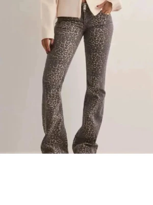 Leopard jeans  - Snygga byxor med leopardmönster och bootcut-snitt. Byxorna har en mörk basfärg med ljusare leopardfläckar och klassisk femficksdesign. Perfekta för dig som vill sticka ut med en trendig look. Low waist 