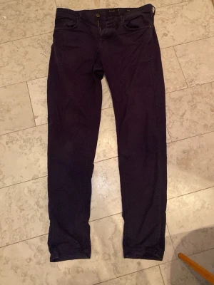 Mörkblå chinos från Massimo Dutti - Snygga mörkblå byxor från Massimo Dutti med klassisk femficksdesign och smal passform. Tillverkade i ett mjukt bomullsmaterial med lite stretch för extra komfort. Perfekta till en stilren och avslappnad look.