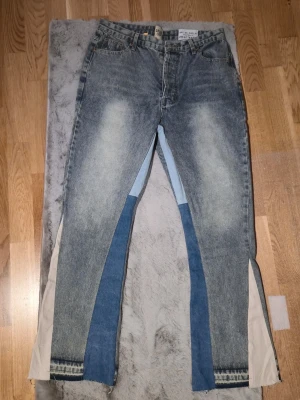 Gallery Dept patchwork jeans blå - Unika patchwork jeans från Gallery Dept med flera olika blå nyanser och kontrasterande tygpaneler längs benen. Klassisk femficksmodell med raka ben och råa kanter nertill. Märkesdetaljer i midjan och cool vintage tvätt. Perfekta för dig som vill sticka ut. Pris kan diskuteras vid snabb affär. 