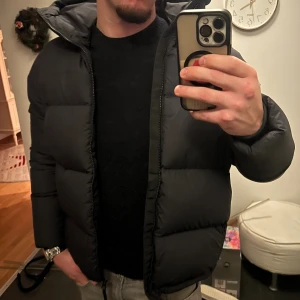 Svart pufferjacka Peak Performance M - Säljer en svart pufferjacka från Peak Performance i storlek M. Köptes innan vintern men när vintern väl kom och jag använde den insåg jag att det inte var rätt modell för mig, så jag köpte en annan jacka istället. Jackan är därför helt oanvänd och i nyskick.  Nypris:4200, mitt pris: 3200