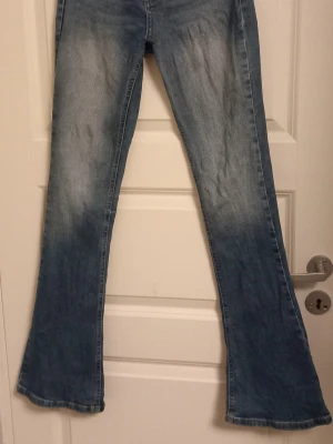 Blå bootcut jeans från Gina Tricot S - Säljer ett par blå bootcut jeans från Gina Tricot, modell 'perfect jeans'. Klassisk femficksdesign, snygg tvätt med slitningar och kontrastsömmar. Jeansen har normal passform.