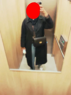 Svart lång kappa M - Säljer en svart lång kappa med klassisk krage och knäppning framtill. Jackan har en rak och stilren passform som funkar perfekt till jeans eller mjukisbyxor. Enkel och tidlös design som är lätt att matcha med olika outfits.