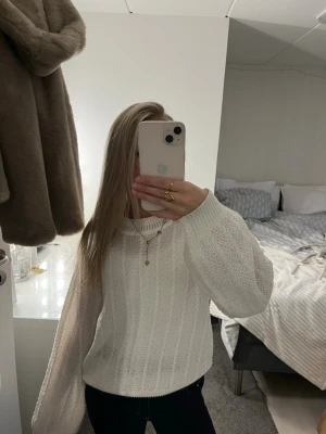 Vit stickad tröja med ballongärmar - Säljer en vit stickad tröja med snygga ballongärmar och rund hals. Tröjan har ett diskret mönster i stickningen och är perfekt för lager-på-lager. Supermjuk och passar till allt! Fråga gärna om du vill veta mer om storlek.